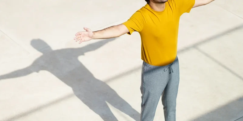 man in yellow shirt arms out