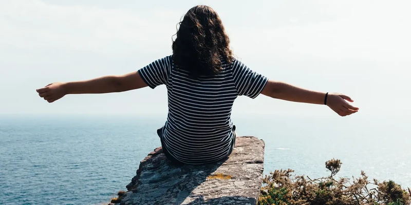 woman sitting on a cliff
