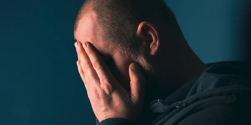 man with hands on face